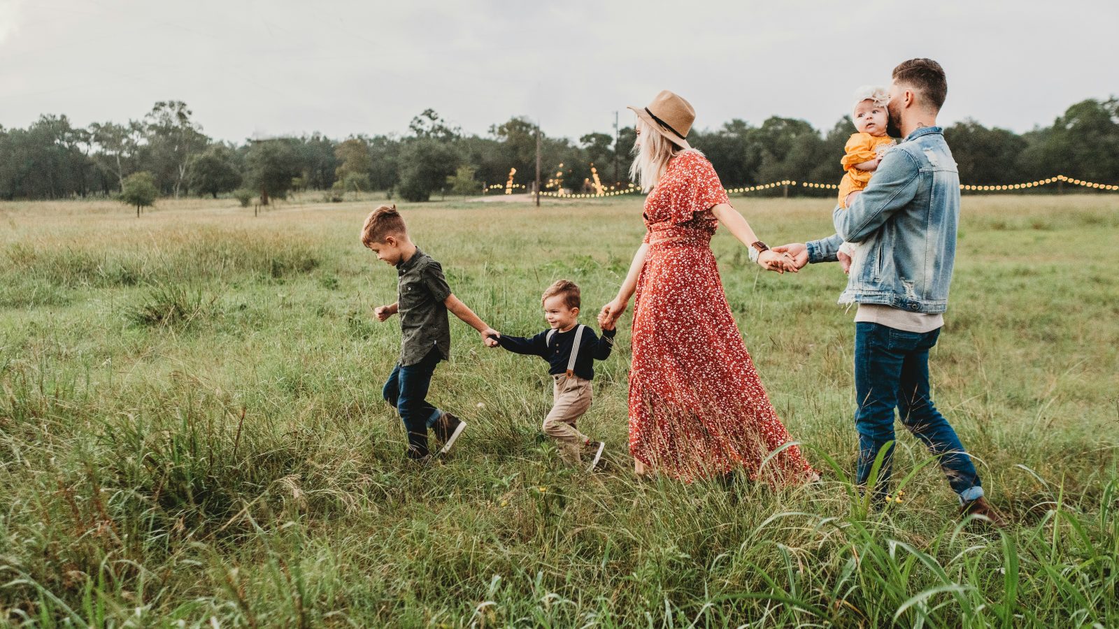 woman holding man and toddler hands during daytime