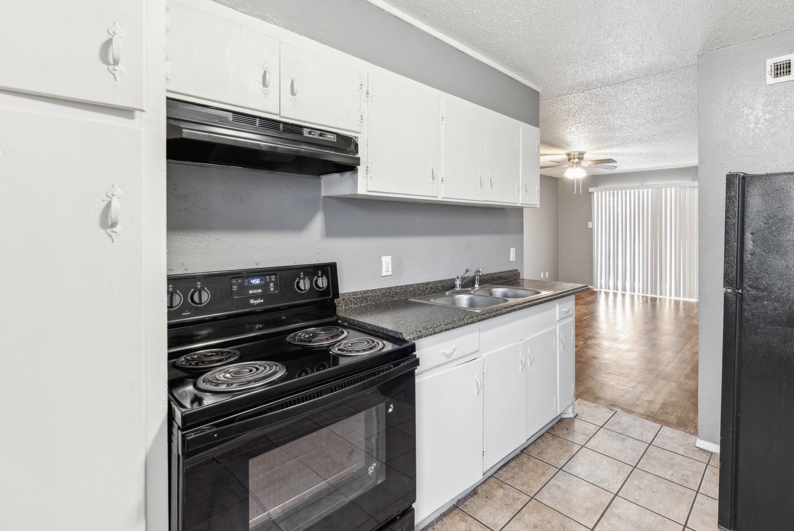 a kitchen with black appliances and white cabinets at The Crestwood Terrace